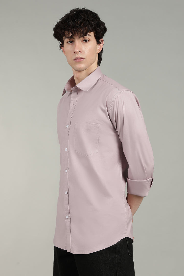 Man wearing a mute pink shirt against a gray background