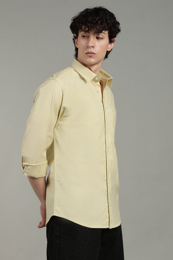 Man wearing a light yellow shirt with a gray background