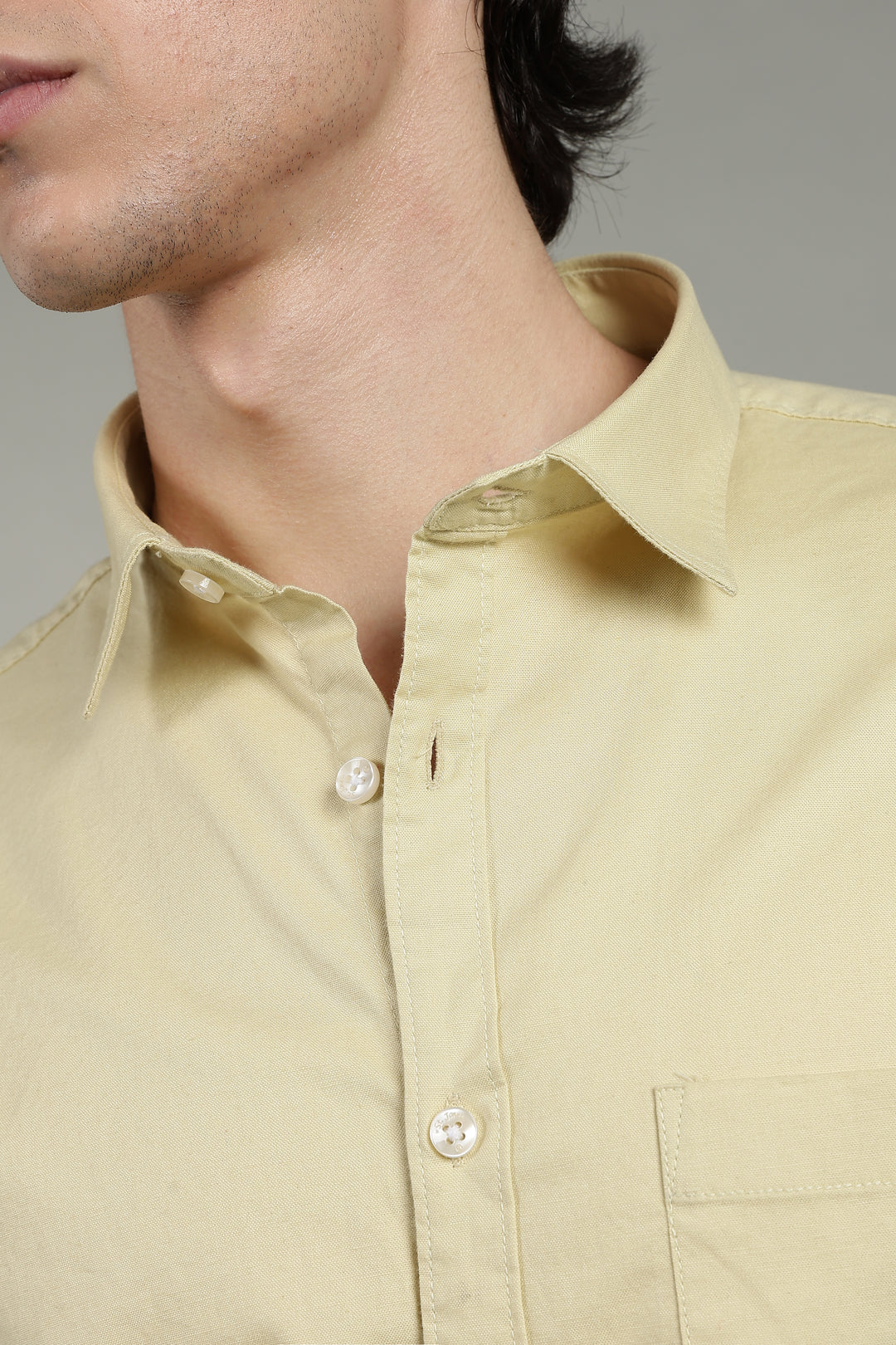 Close-up of a yellow shirt with a gray background