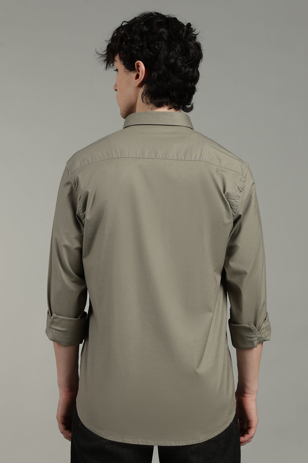 man  wearing a sage green shirt against a gray background