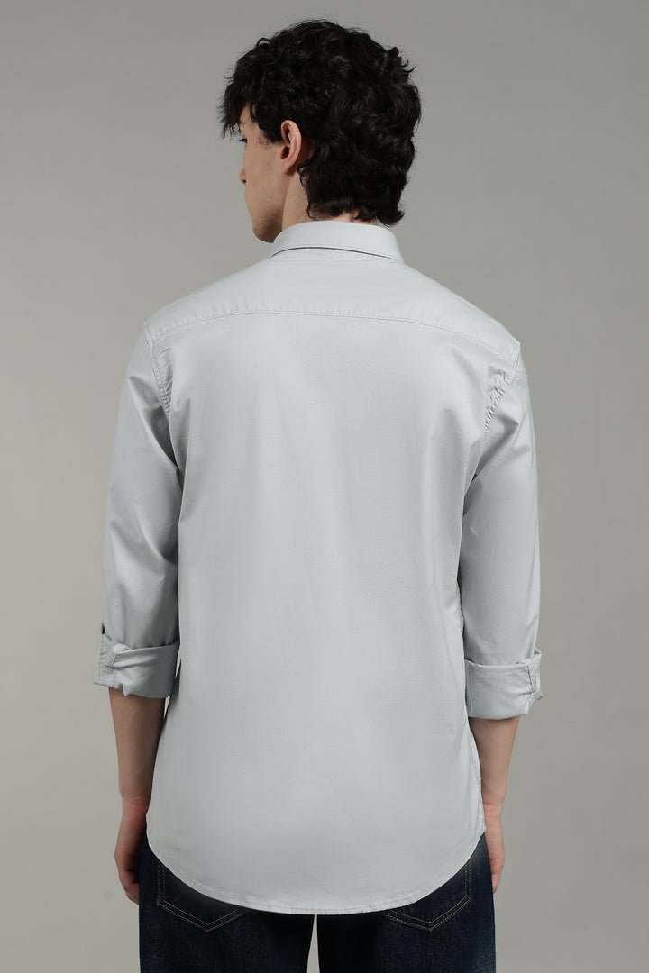 man wearing a icy blue shirt against a plain background