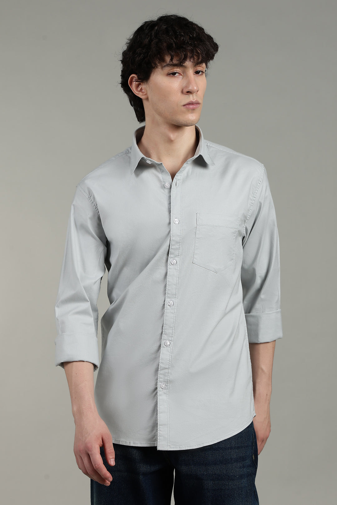 man wearing a icy blue button-up shirt against a plain background