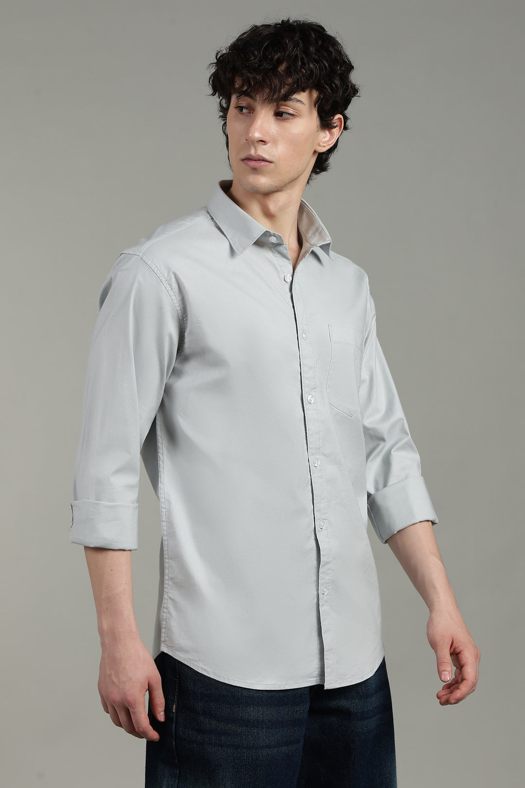 Man wearing a icy blue shirt against a gray background