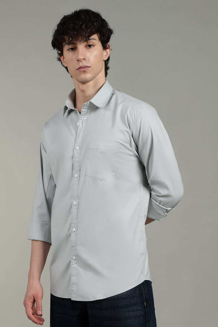 Man wearing a icy blue button-up shirt against a plain background