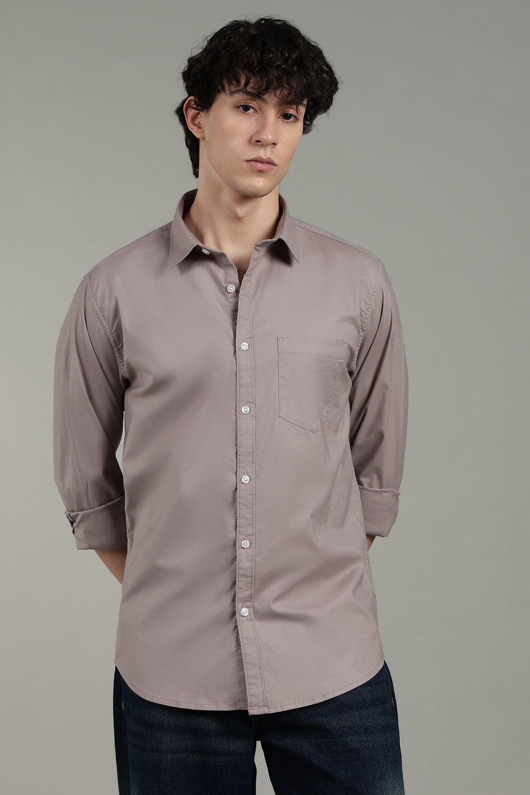 Man wearing a light mink button-up shirt against a gray background