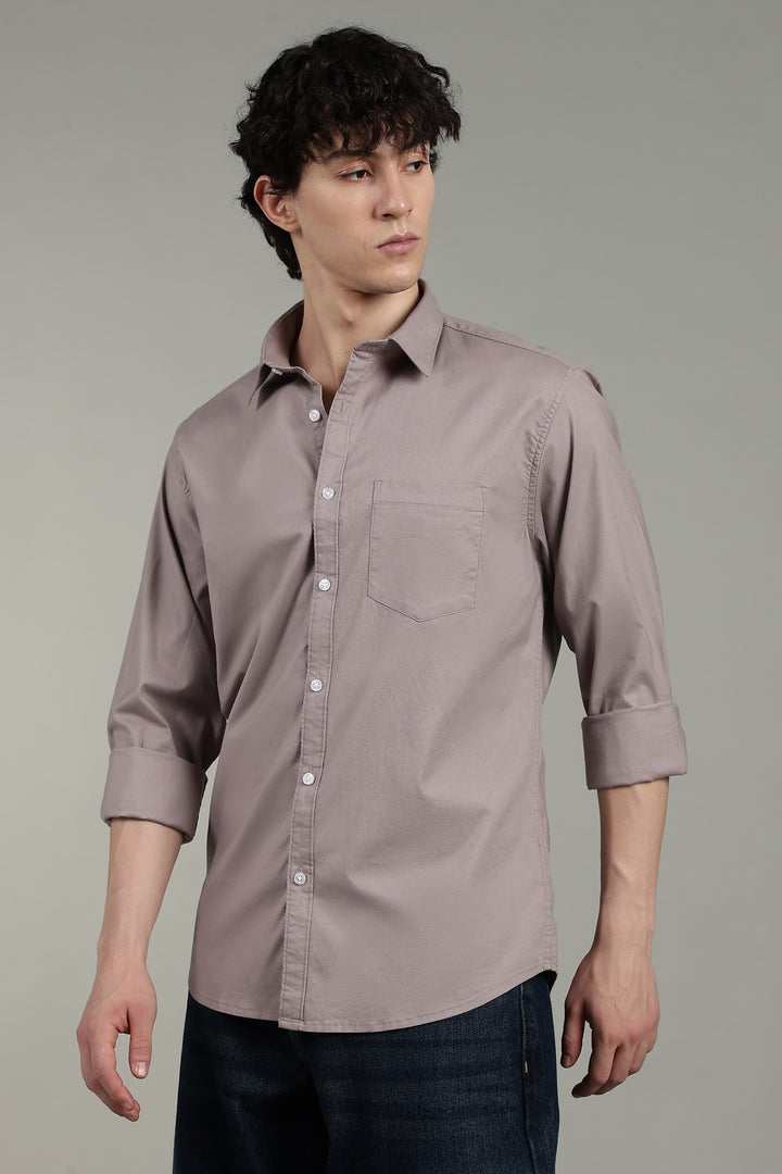 Man wearing a light mink button-up shirt against a gray background