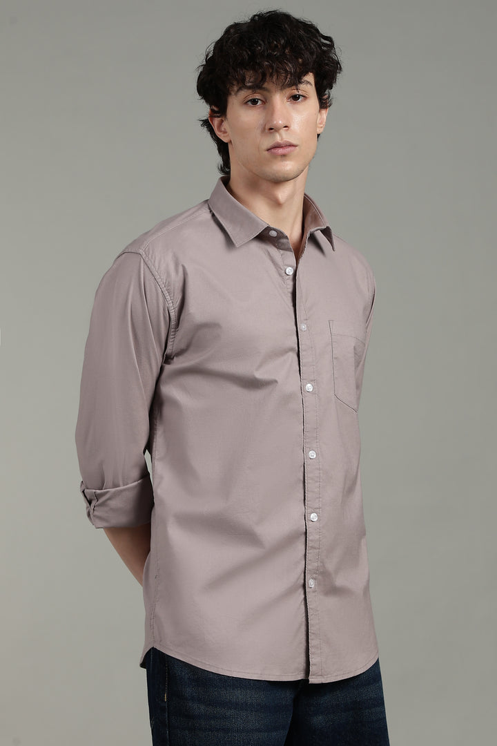 Man wearing a light mink button-up shirt against a gray background