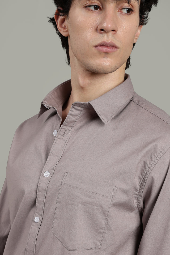 Man wearing a light mink shirt against a gray background