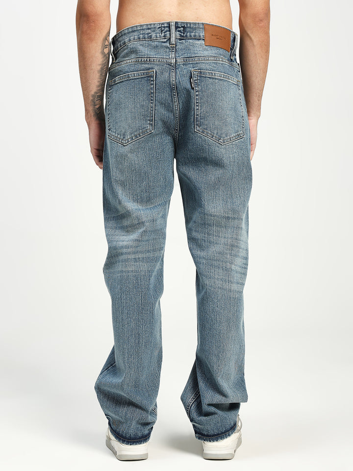 man wearing light blue jeans on a white background