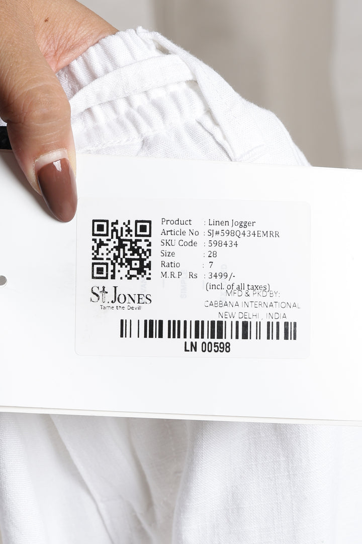 Close-up of a white linen pant with a label featuring a QR code and text.