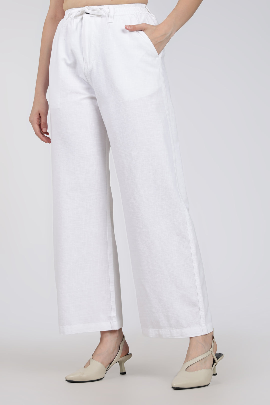 woman wearing white pants on a plain background