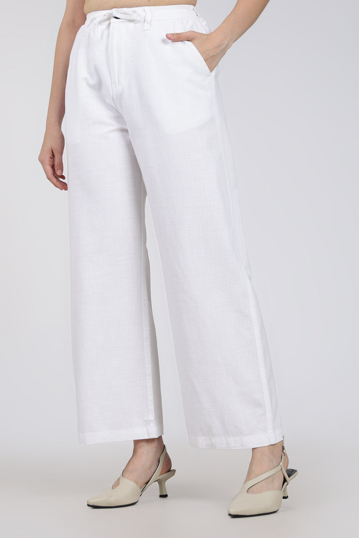 woman wearing white pants on a plain background