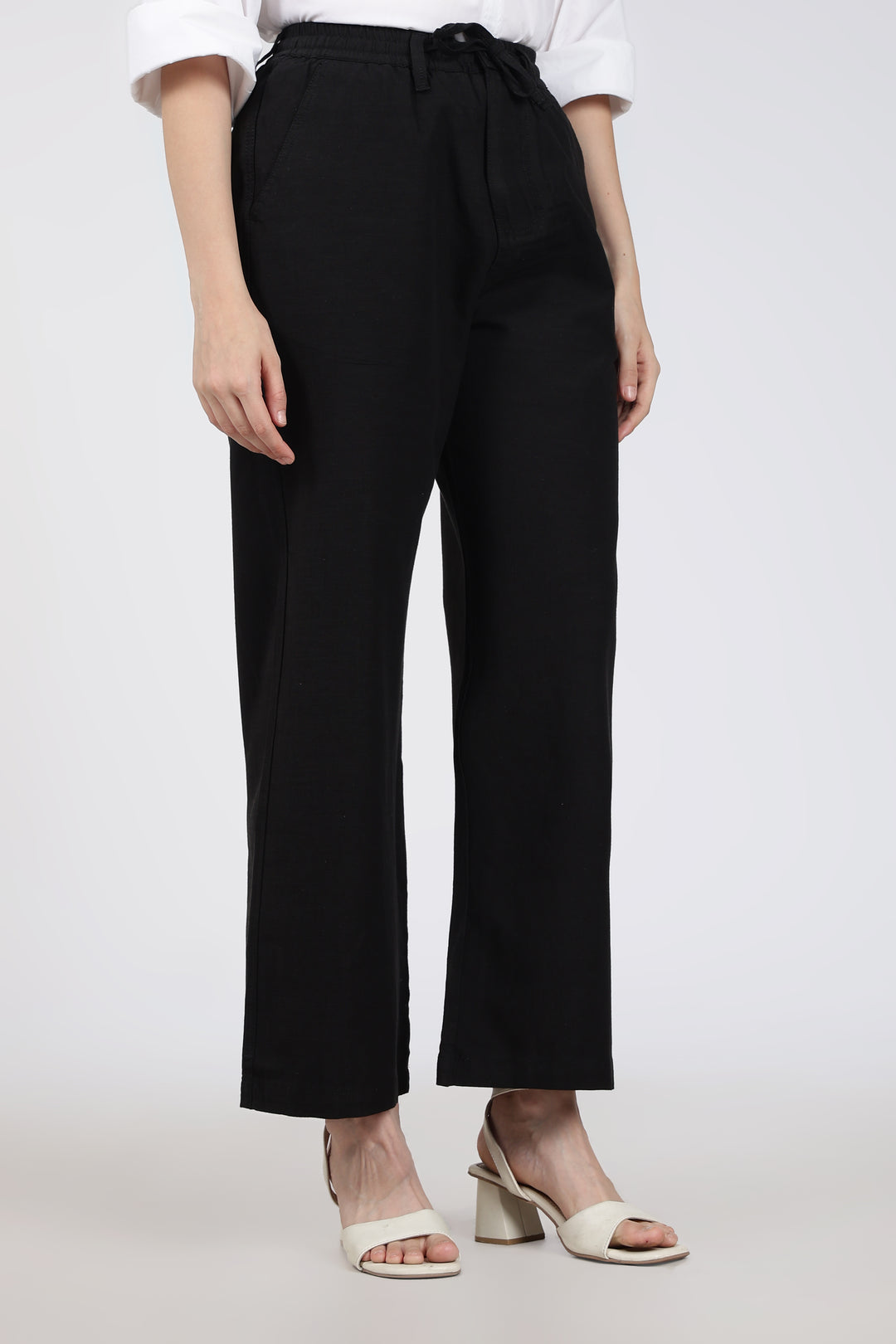 woman wearing black pants with a tie waist on a white background