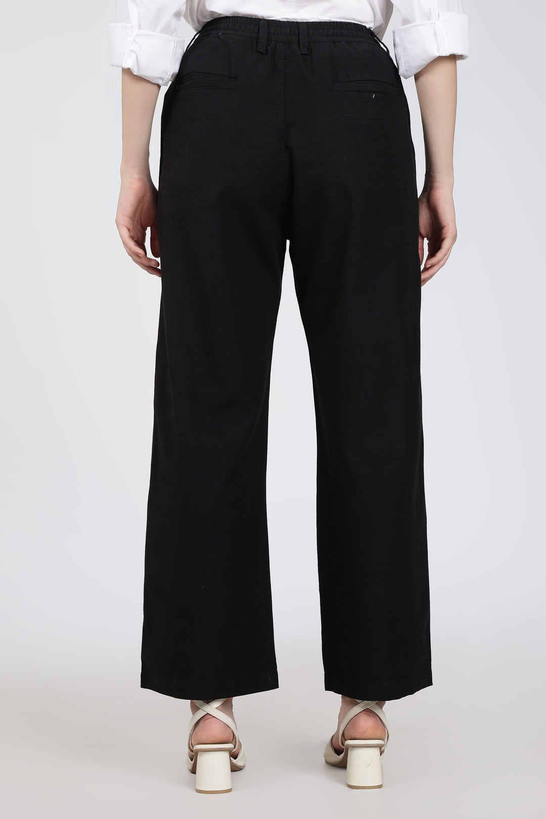 woman wearing black wide-leg pants on a white background