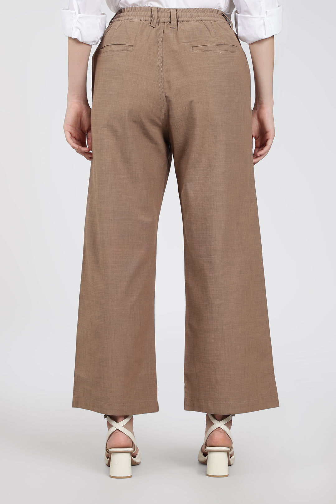 Brown wide-leg pants worn by a woman on a white background