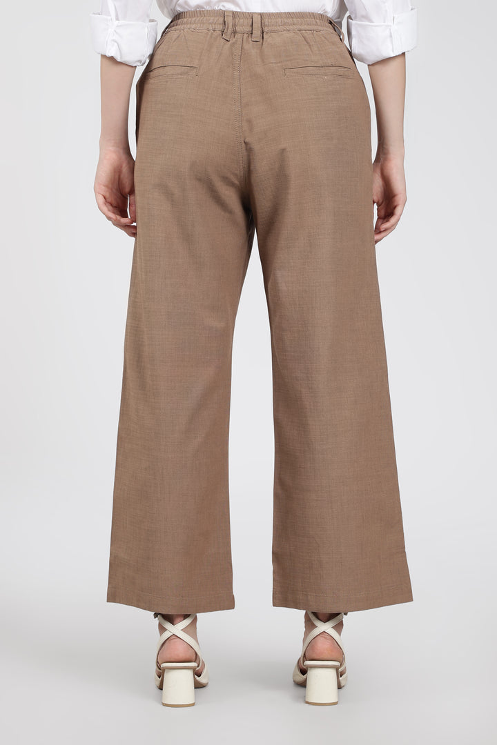Brown wide-leg pants worn by a woman on a white background