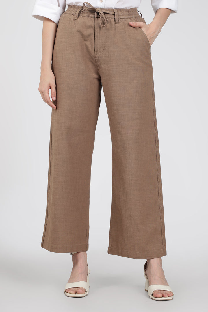 Brown wide-leg pants worn by a woman on a white background